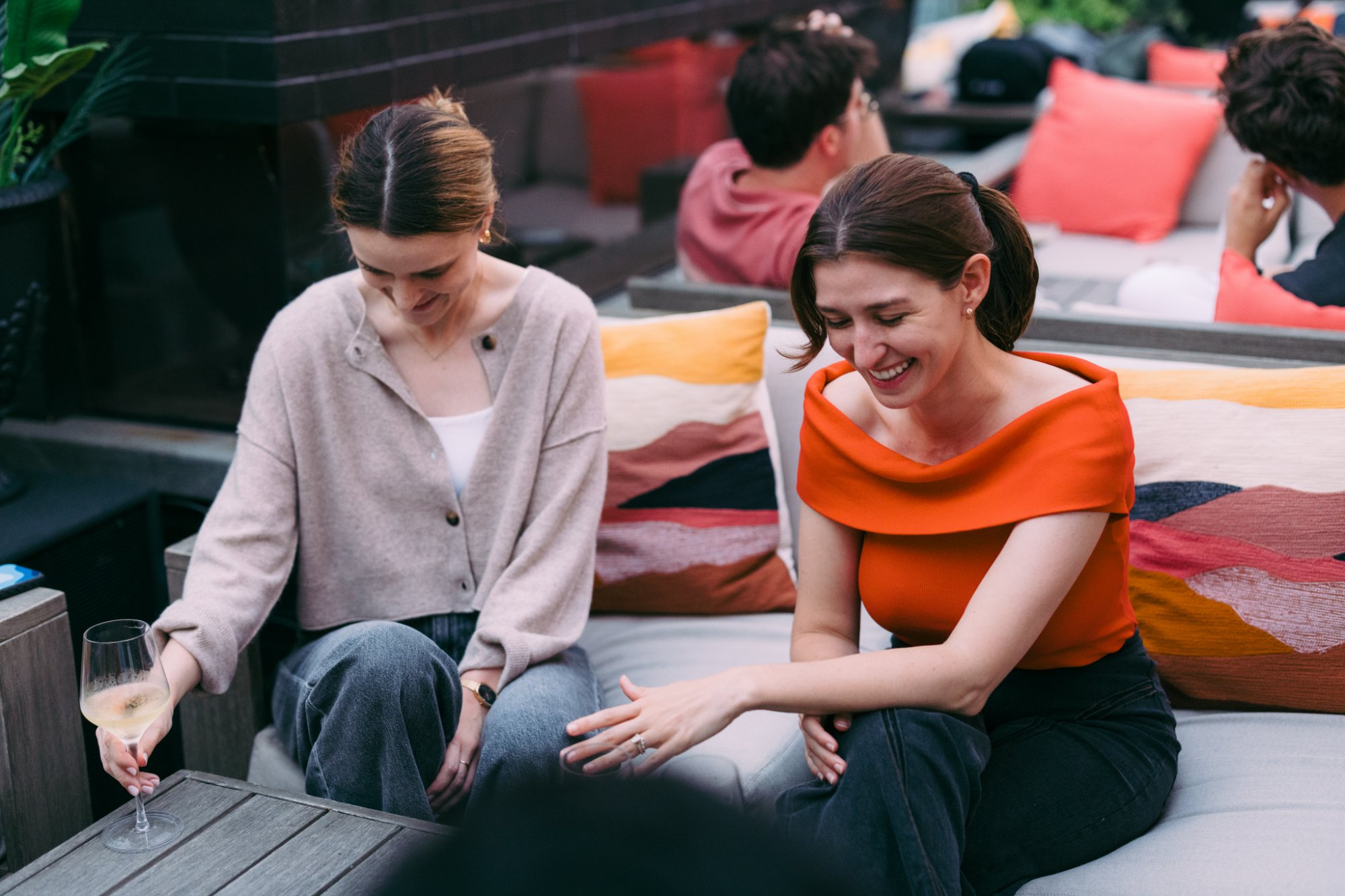Two Check teammates laughing on a rooftop couch