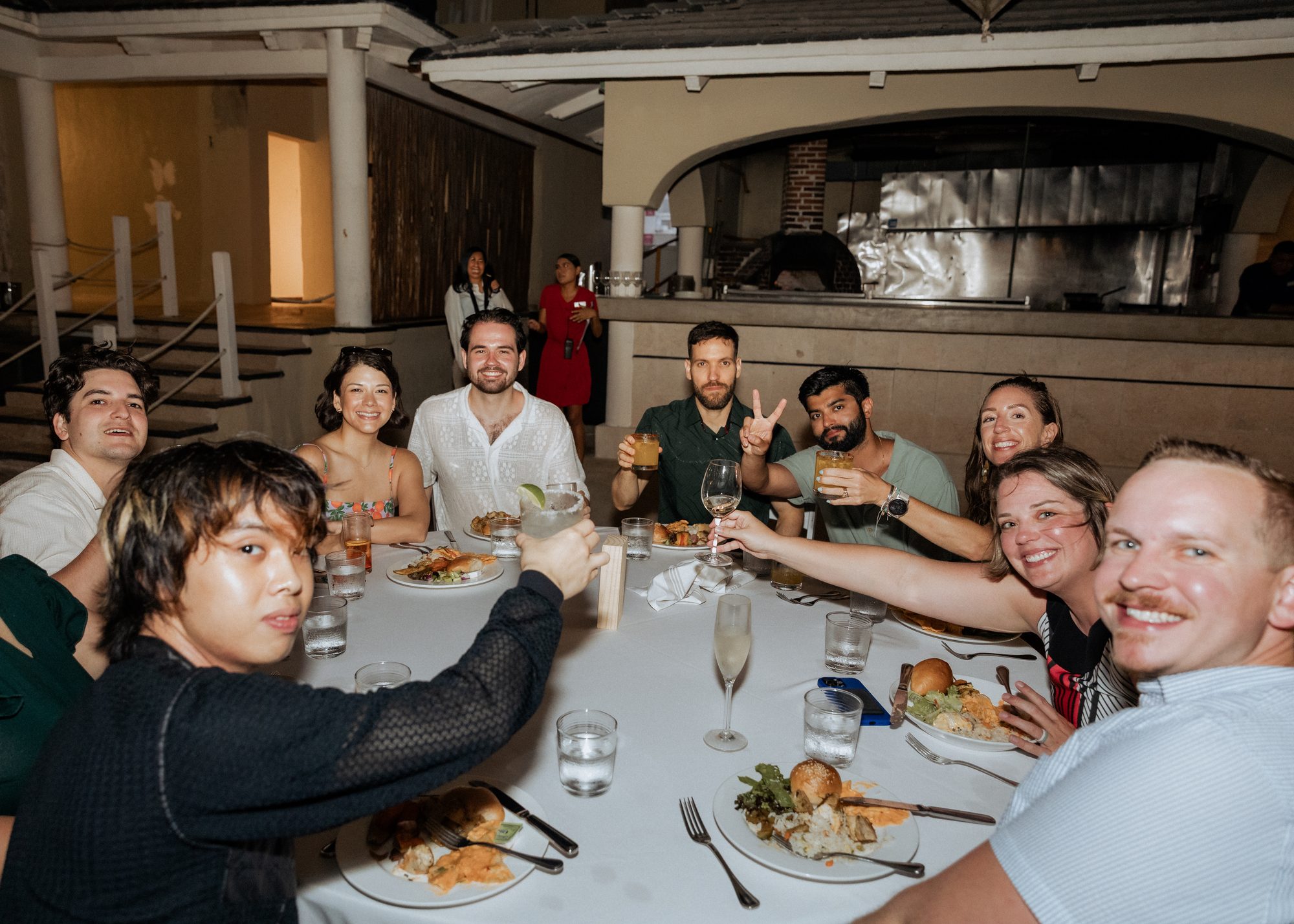 Check teammates raising a toast at dinner during the company offsite