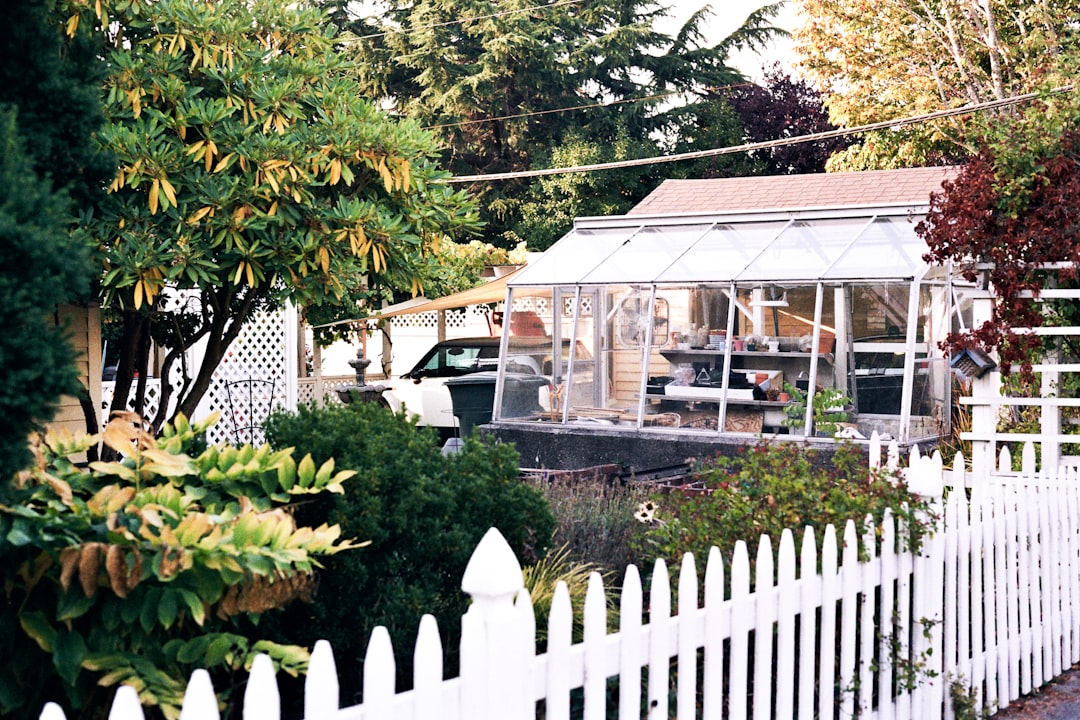 A white vinyl picket fence in front of a classic New England style home - fence companies in southern nh A white vinyl picket fence in front of a classic New England style home - fence companies in southern nh