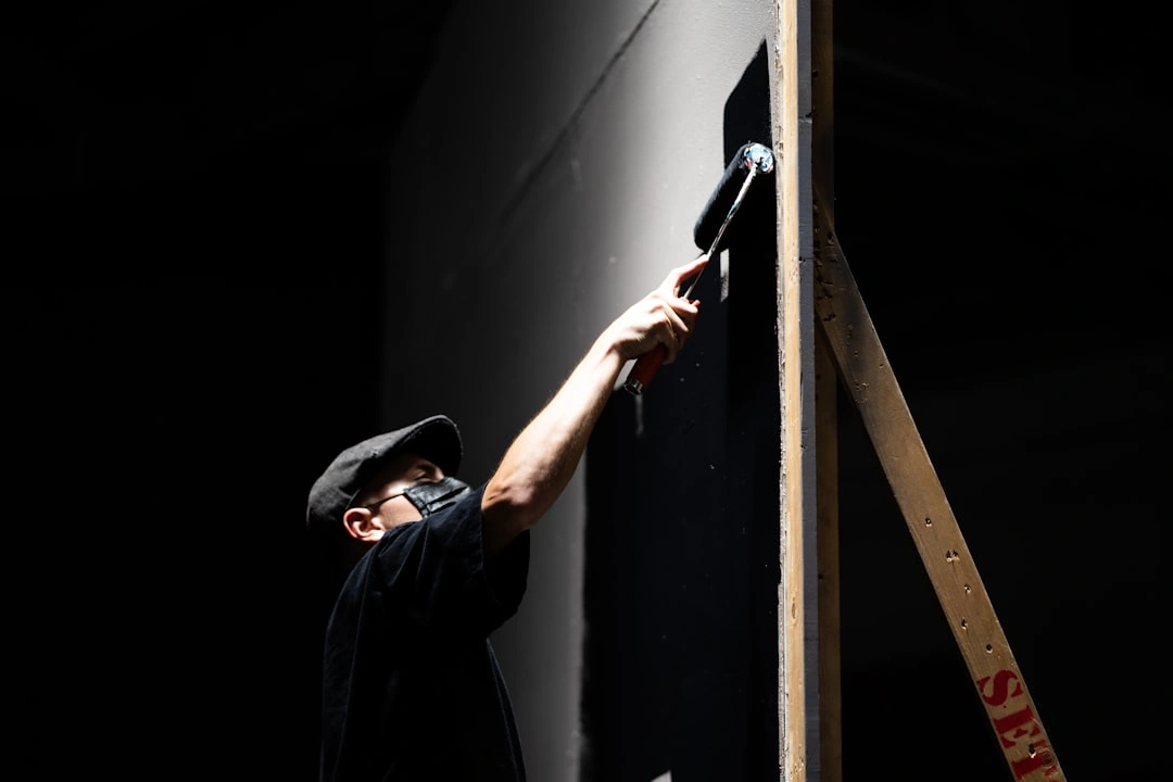 Professional painters applying stain to a wooden fence Professional painters applying stain to a wooden fence