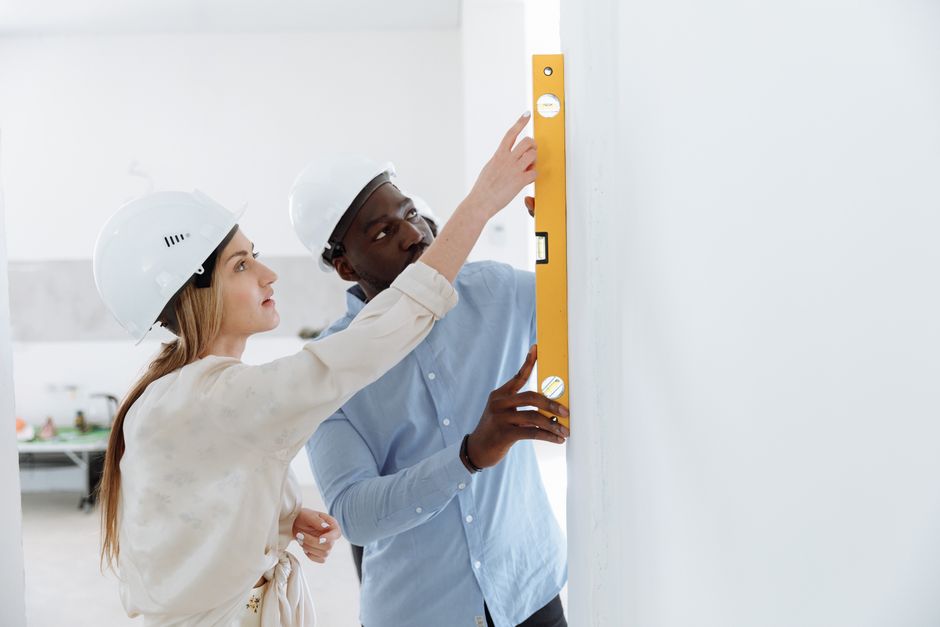 professional installer checking plumb of a chain link fence post with a level professional installer checking plumb of a chain link fence post with a level