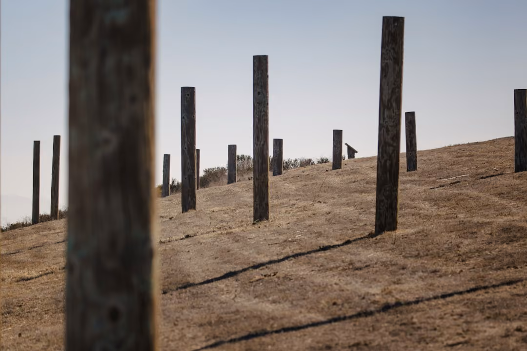 professional fence installers setting wood posts in ground