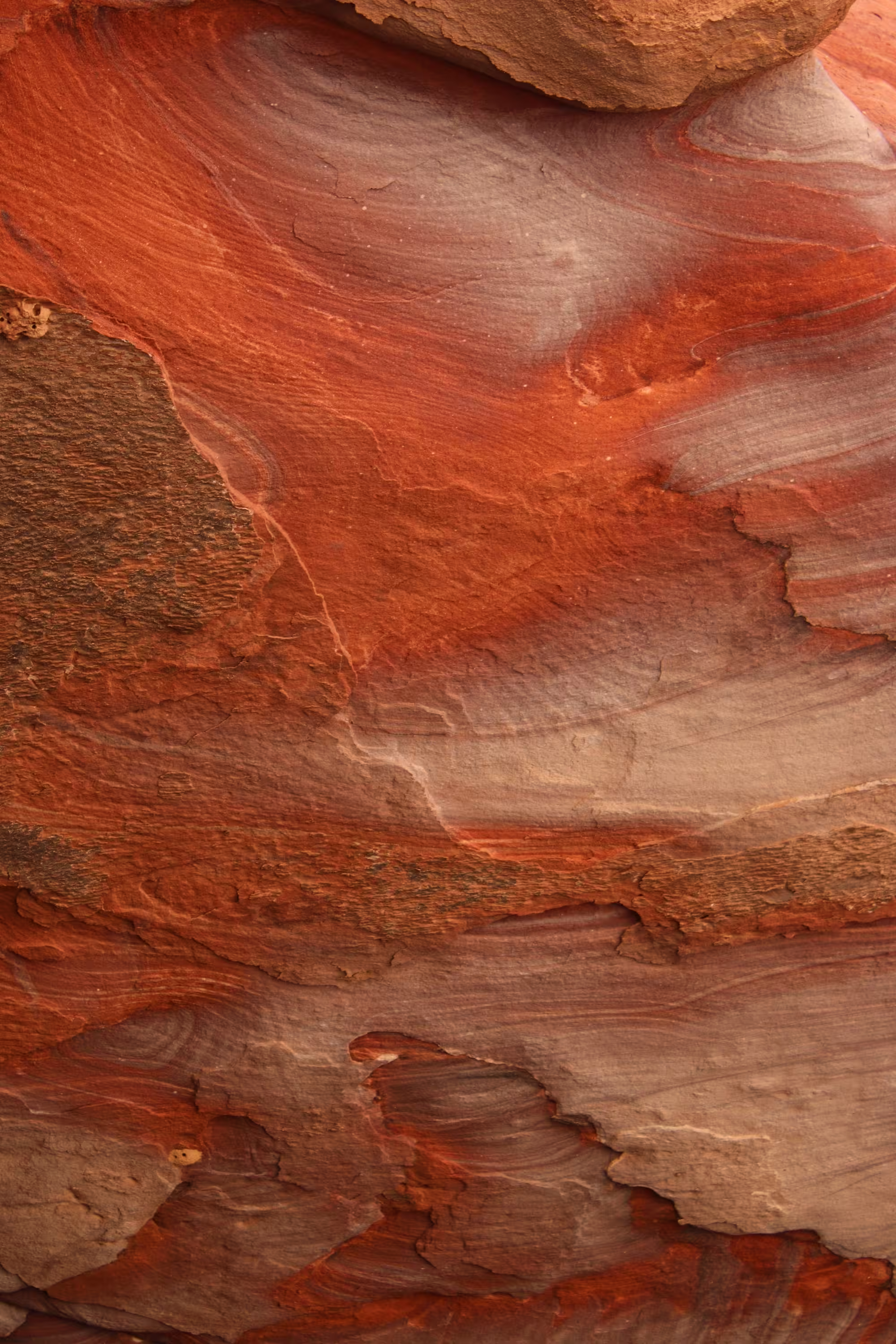 Close-up of red and brown layered sandstone rock texture with natural striations.