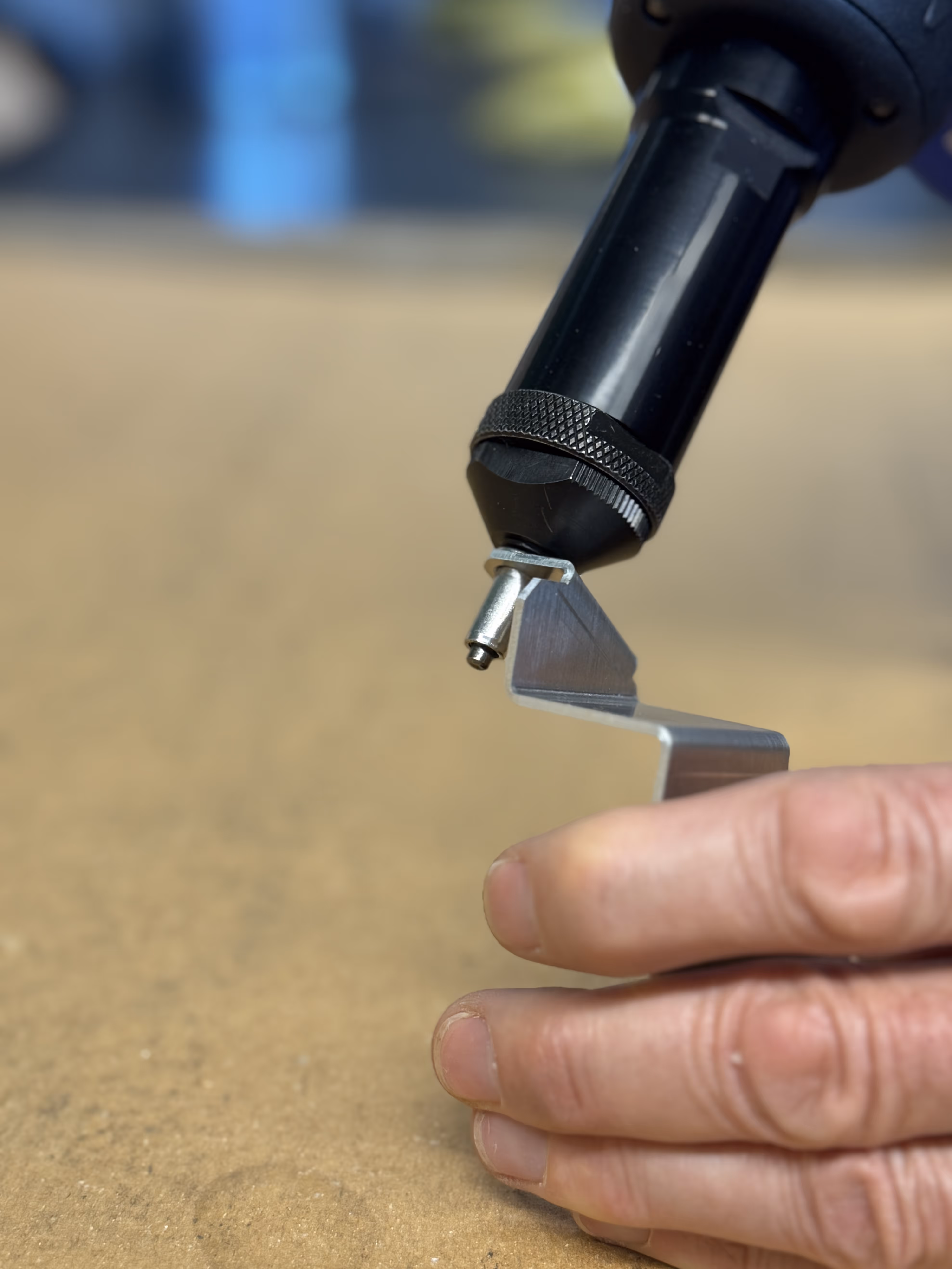 Eine Hand hält eine Vorrichtung für die Niettechnik