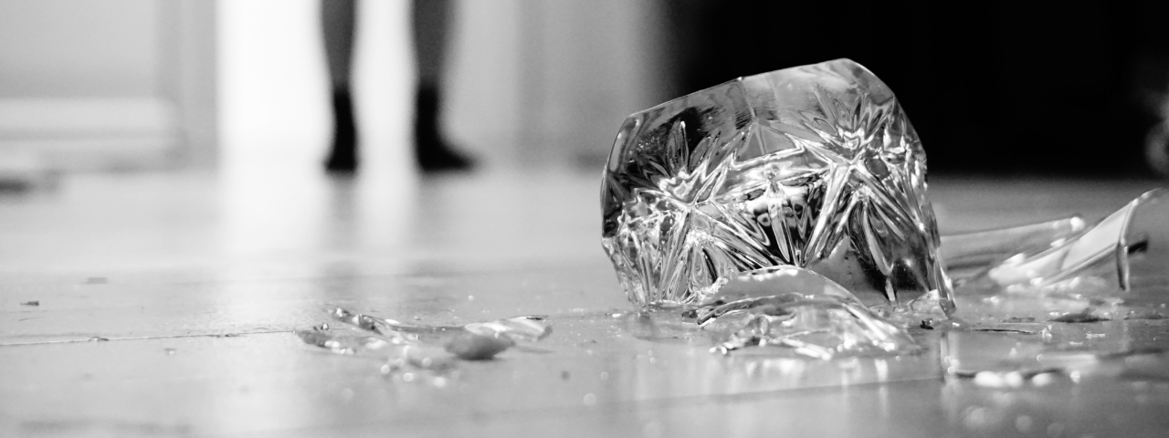 Broken glass on the floor with blurred feet in the background, symbolizing the aftermath of launching a store without proper preparation.