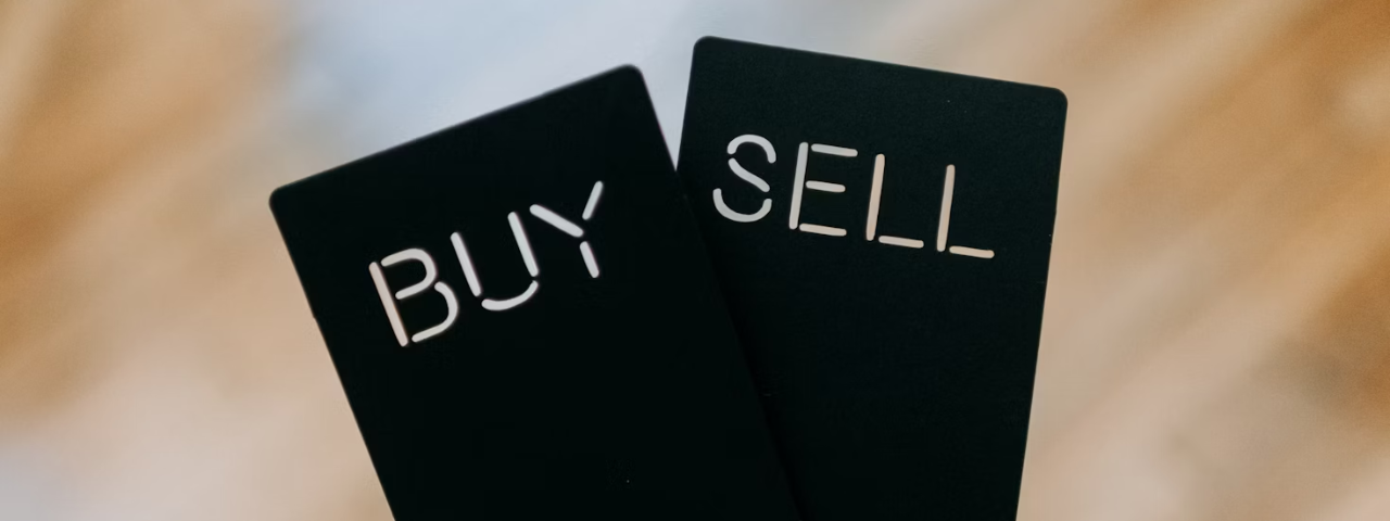 Two black cards with the words BUY and SELL cut out, symbolizing the core actions of any online store.