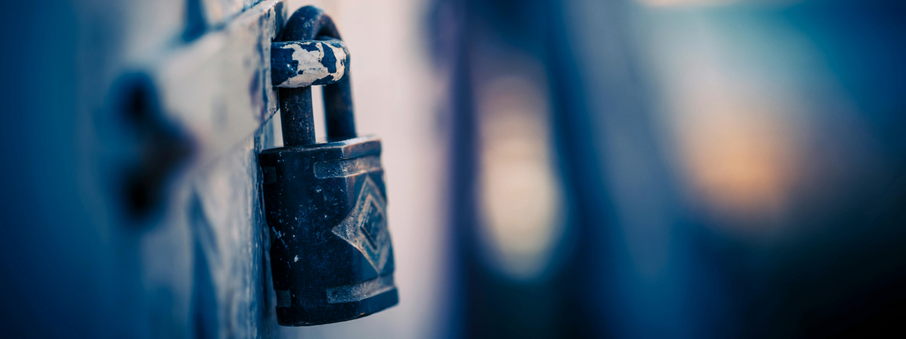 Rusty padlock on a metal gate, symbolizing code security and governance.