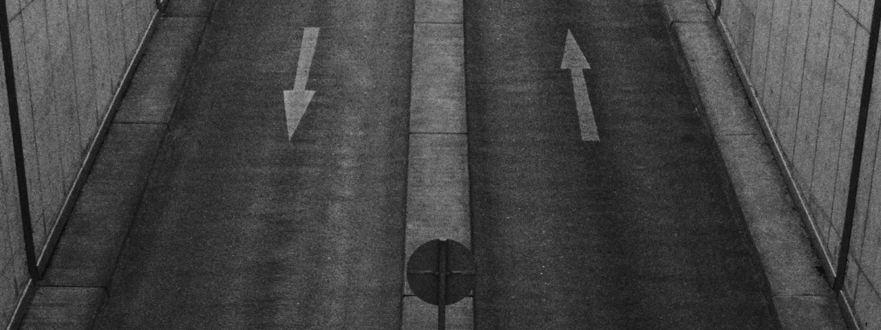 Empty road with arrows pointing in opposite directions, symbolizing clarity versus confusion in store design
