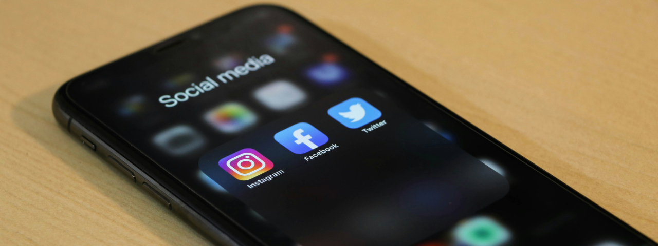 Smartphone screen showing Instagram, Facebook, and Twitter icons — illustrating how niche influencers on social media can outperform paid ads for Shopify stores.