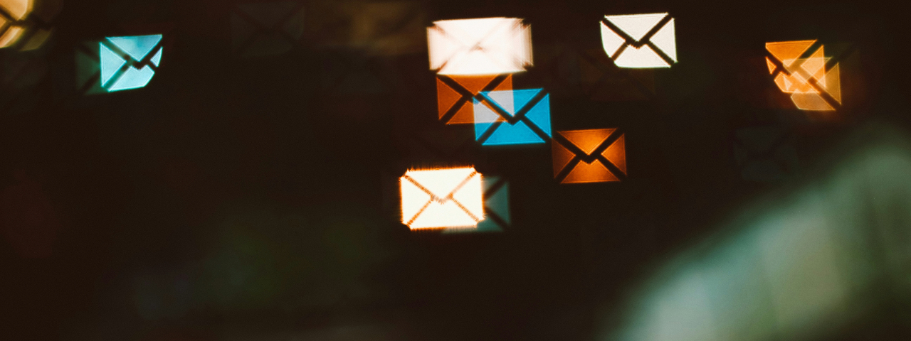 Email envelope icons glowing over blurred background, illustrating email activity and digital messaging.