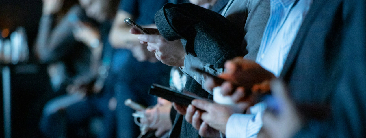 People using smartphones in a crowd, showing how mobile dominates everyday browsing habits.