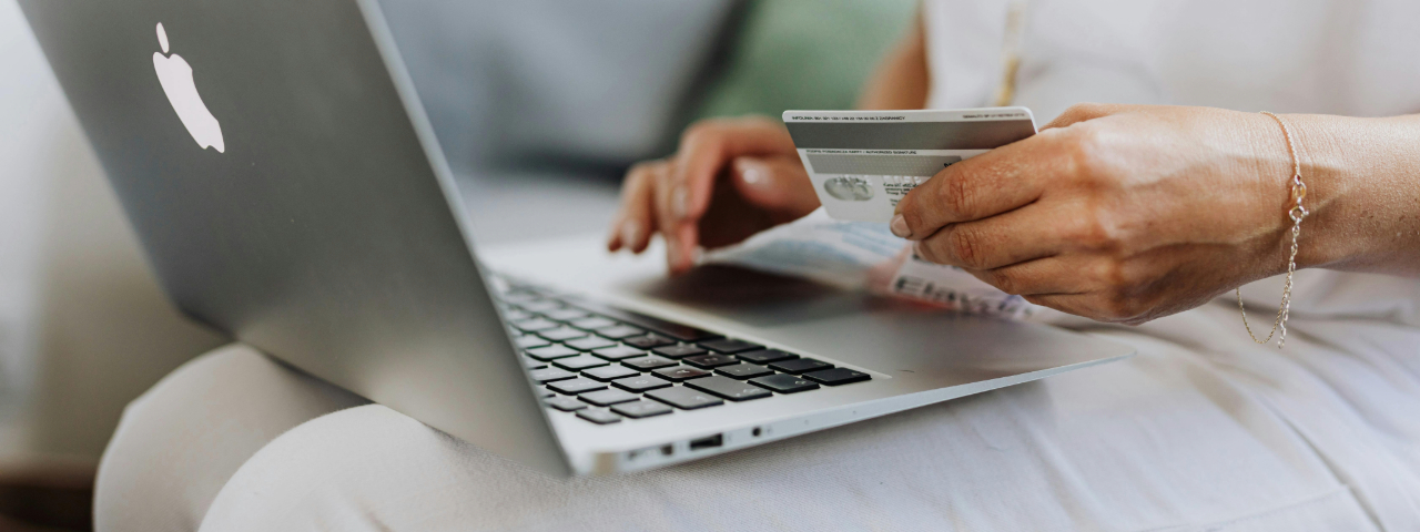 Person making an online purchase using a laptop and credit card, symbolizing modern customer buying behavior.