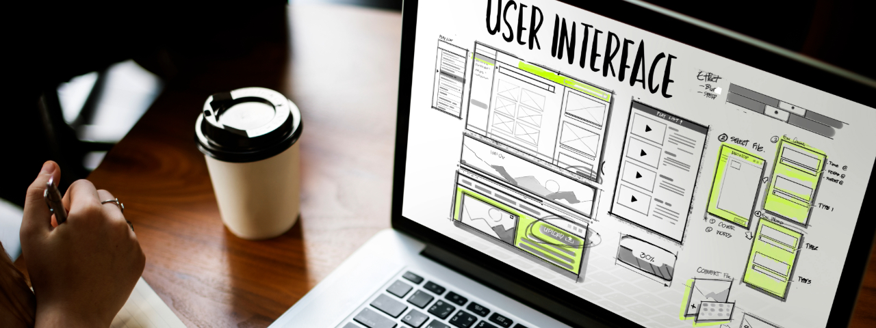 Person sketching a user interface design on a laptop screen, showing layout and functionality for a website