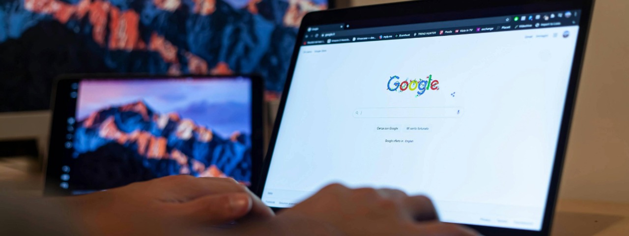 Person typing on a laptop with Google search open, representing modern search behavior for e-commerce shoppers.