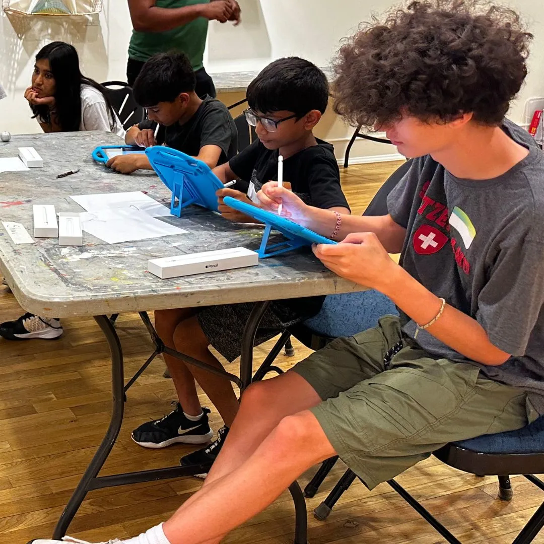 3 boys working on digital work on tablets