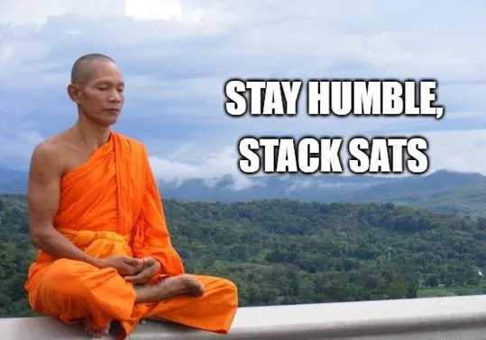 A person in orange robe sitting on a ledgeAI-generated content may be incorrect.