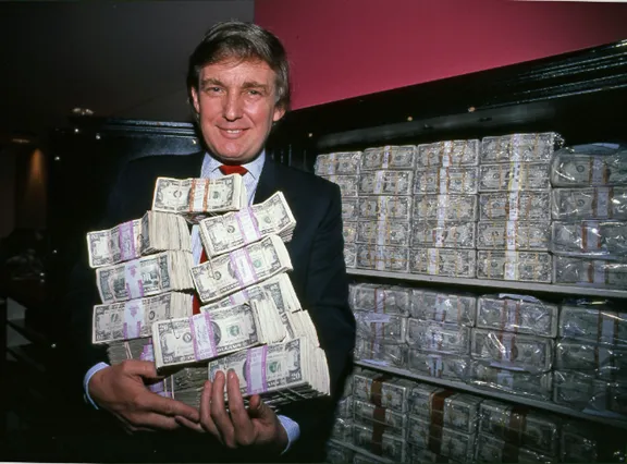 A person holding a large stack of moneyAI-generated content may be incorrect.