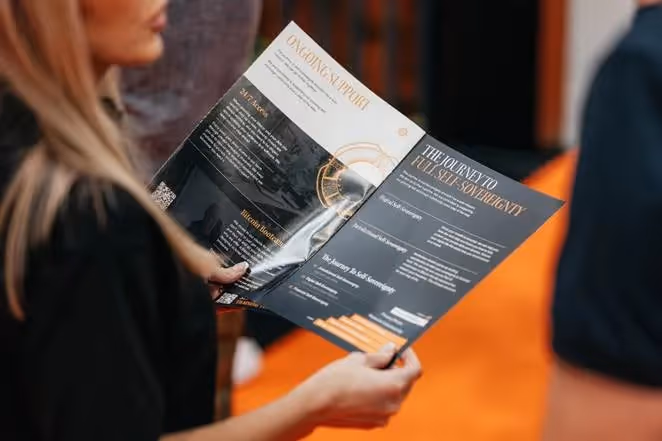 A person holding a black and white brochureAI-generated content may be incorrect.