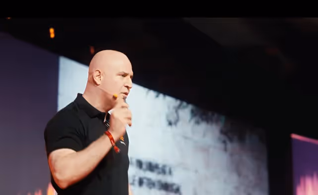 A person speaking into a microphoneAI-generated content may be incorrect.