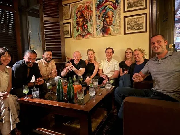 A group of people sitting around a tableAI-generated content may be incorrect.