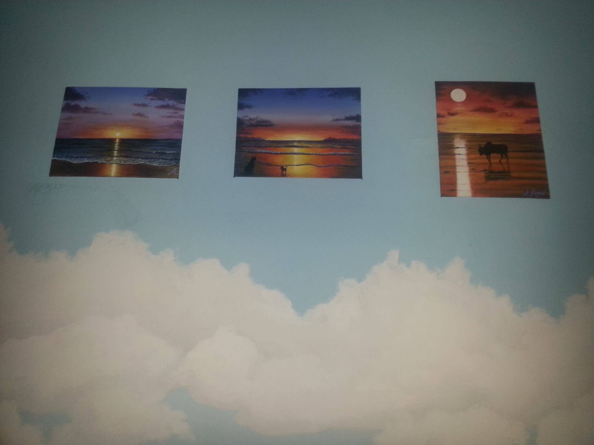 three paintings of a sunset on the wall
