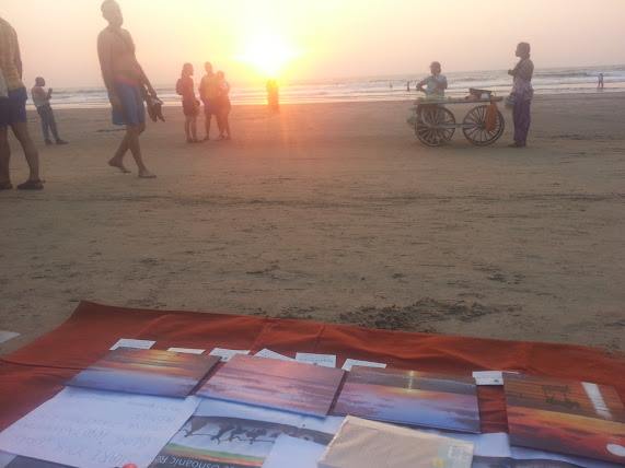 paintings on a market at the beach with the sunset