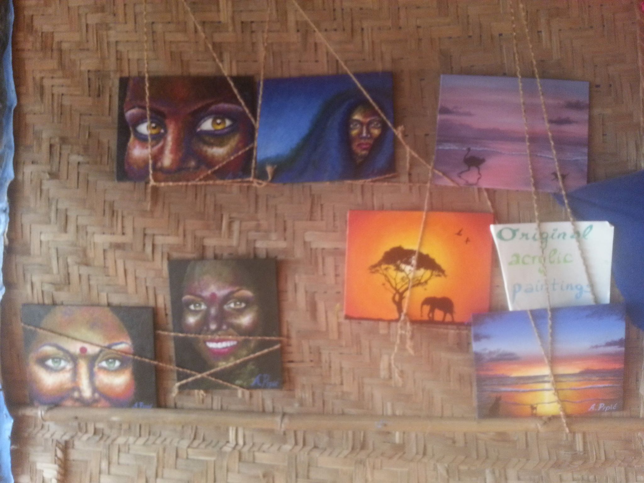 a picture of small beach paintings on a wall of a hut restaurant