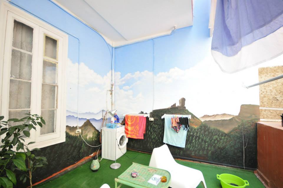 a terrace with high ceiling painted in realistic mountains and sky with clouds