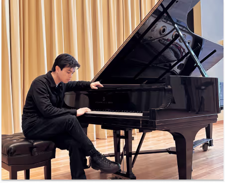Jay touching the grand piano keys
