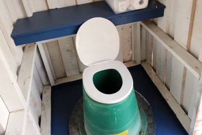 Outhouse toilet in a wooden outdoor outhouse. 