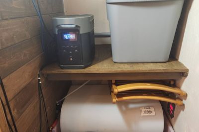 Small solar battery with digital display on wooden shelf.