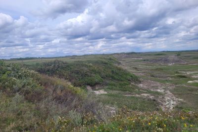 Wide view of coulees and open plains under a cloudy sky.