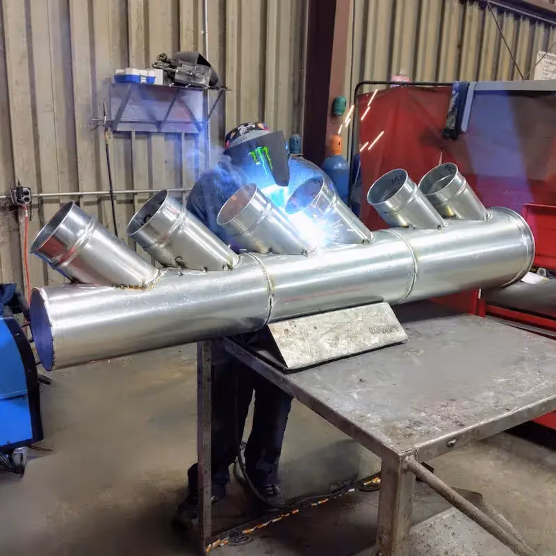 Custom Manifold being welded in a workshop.