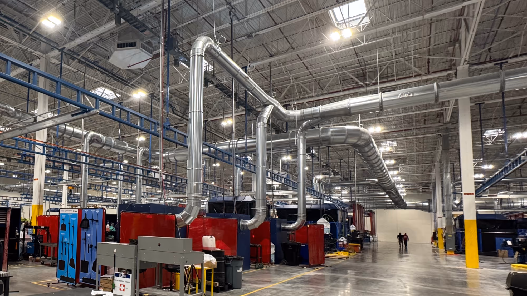 Clamp-together dust collection ductwork system installed in an industrial facility with adjustable duct sections, branches, and collection points.