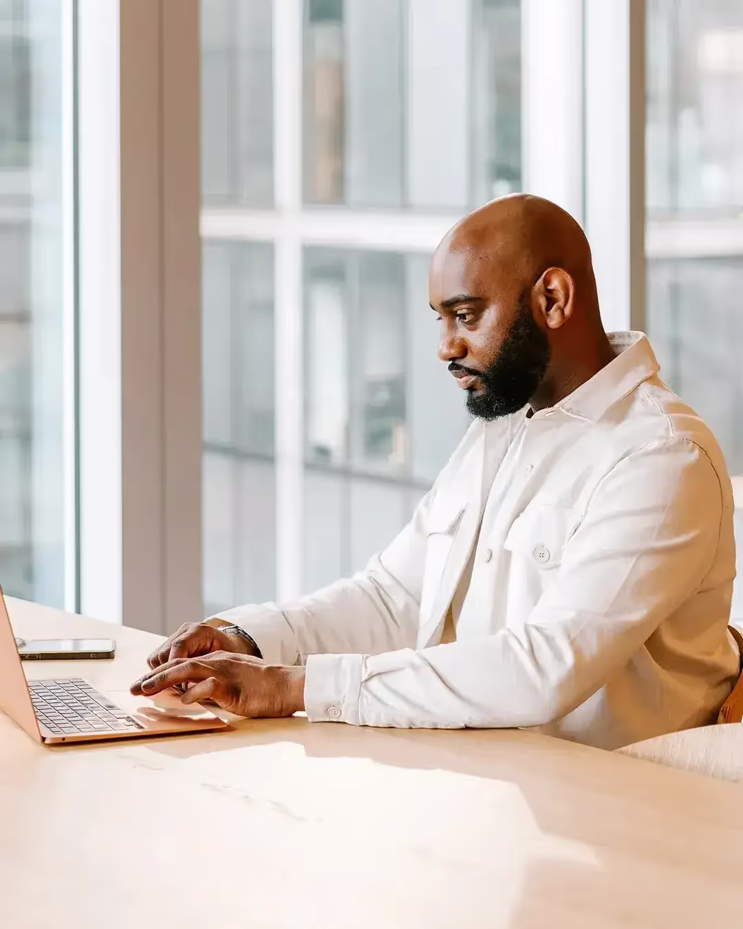 A man sat at a table with his laptop