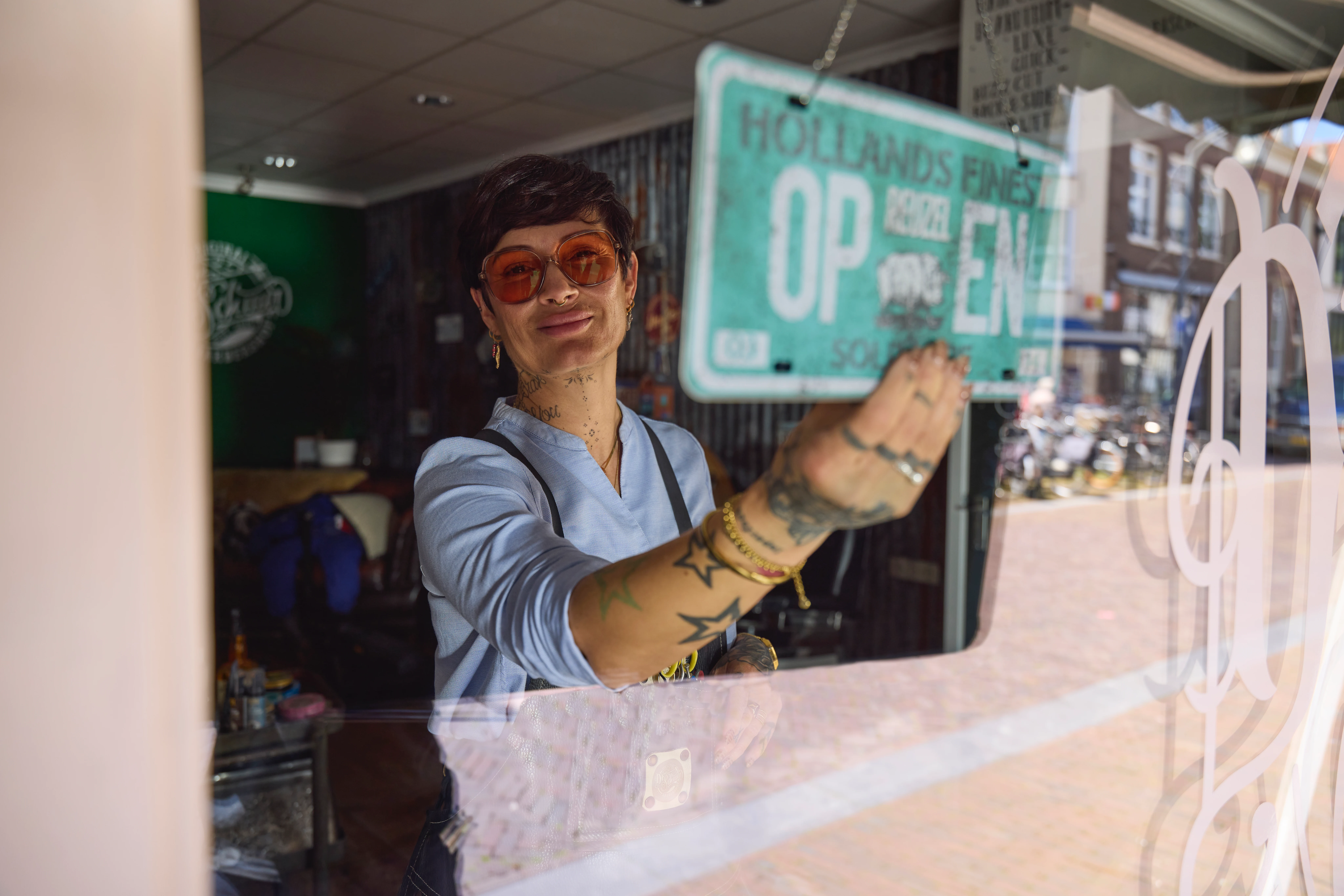 Barbier opent haar winkel en draait 'open' bordje om