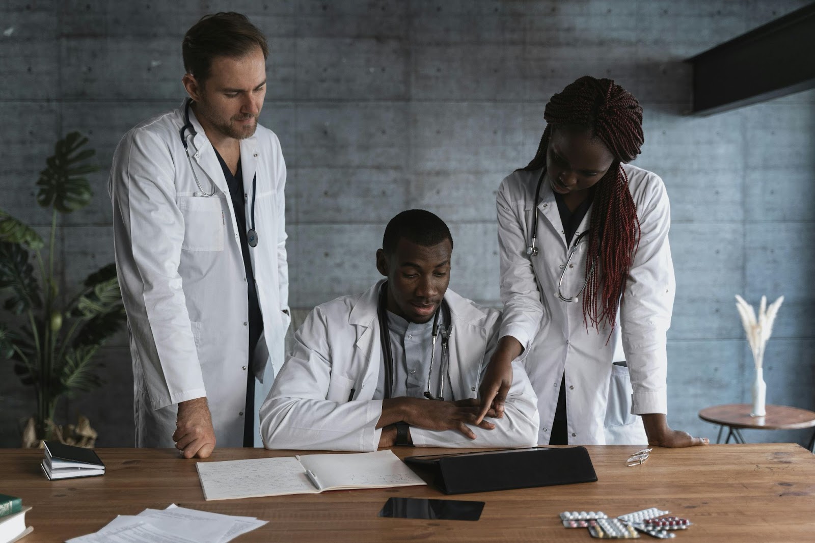 Medical professionals reviewing documents and digital tools at a desk