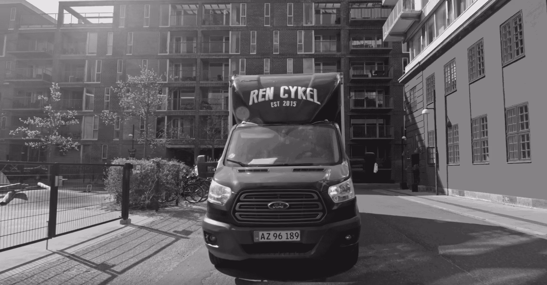Ren Cykel servicevogn parkeret foran lejligheder, klar til cykelreparation og elladcykel service.