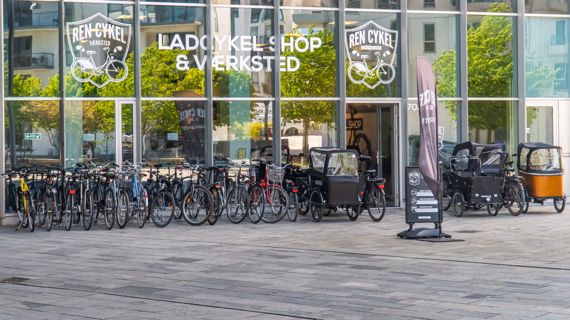 Cykler og christiania ladcykler foran cykelværksted, klar til cykelservice, køb af cykel og reparation.
