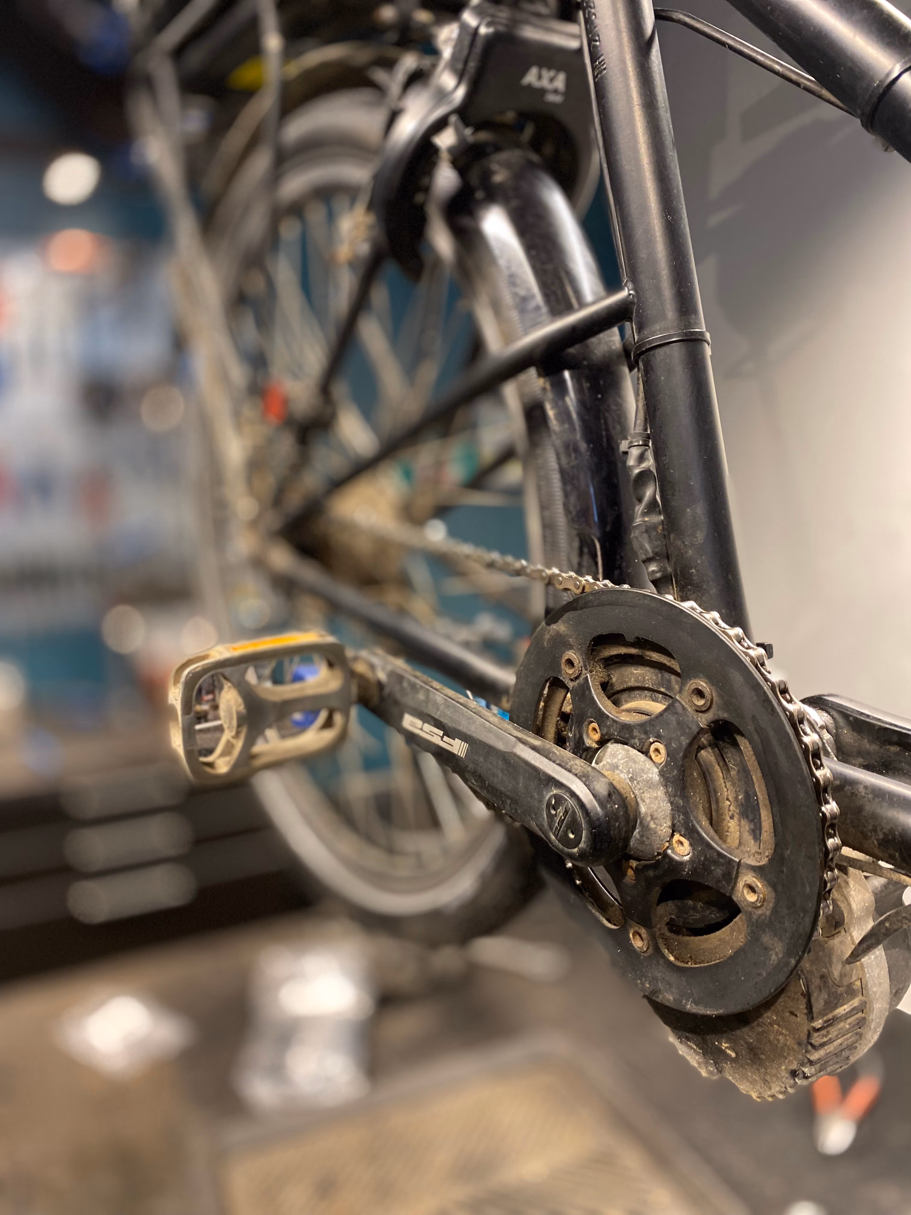 Nærbillede af cykelkæde, tandhjul og bagagebærer på cykel klar til reparation på cykelværksted.