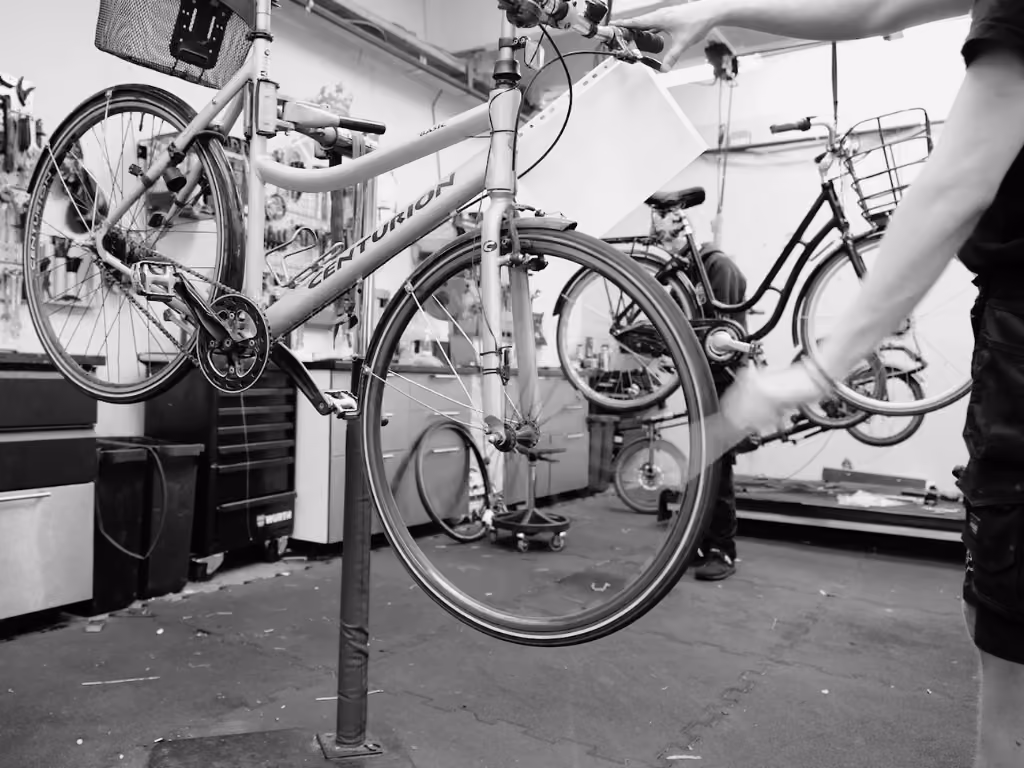 Cykelmekaniker udfører cykelservice og justering af cykel kæde på cykelværksted.