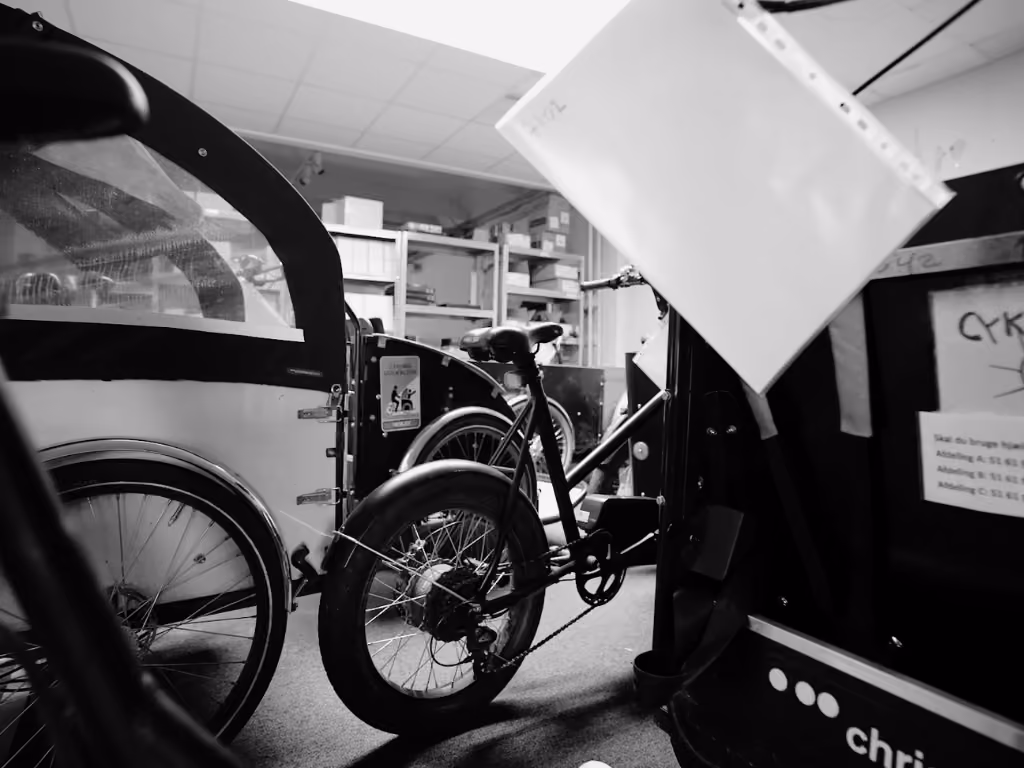 Christiania elladcykler og trehjulede cykler klar til service på cykelværksted med reservedele.