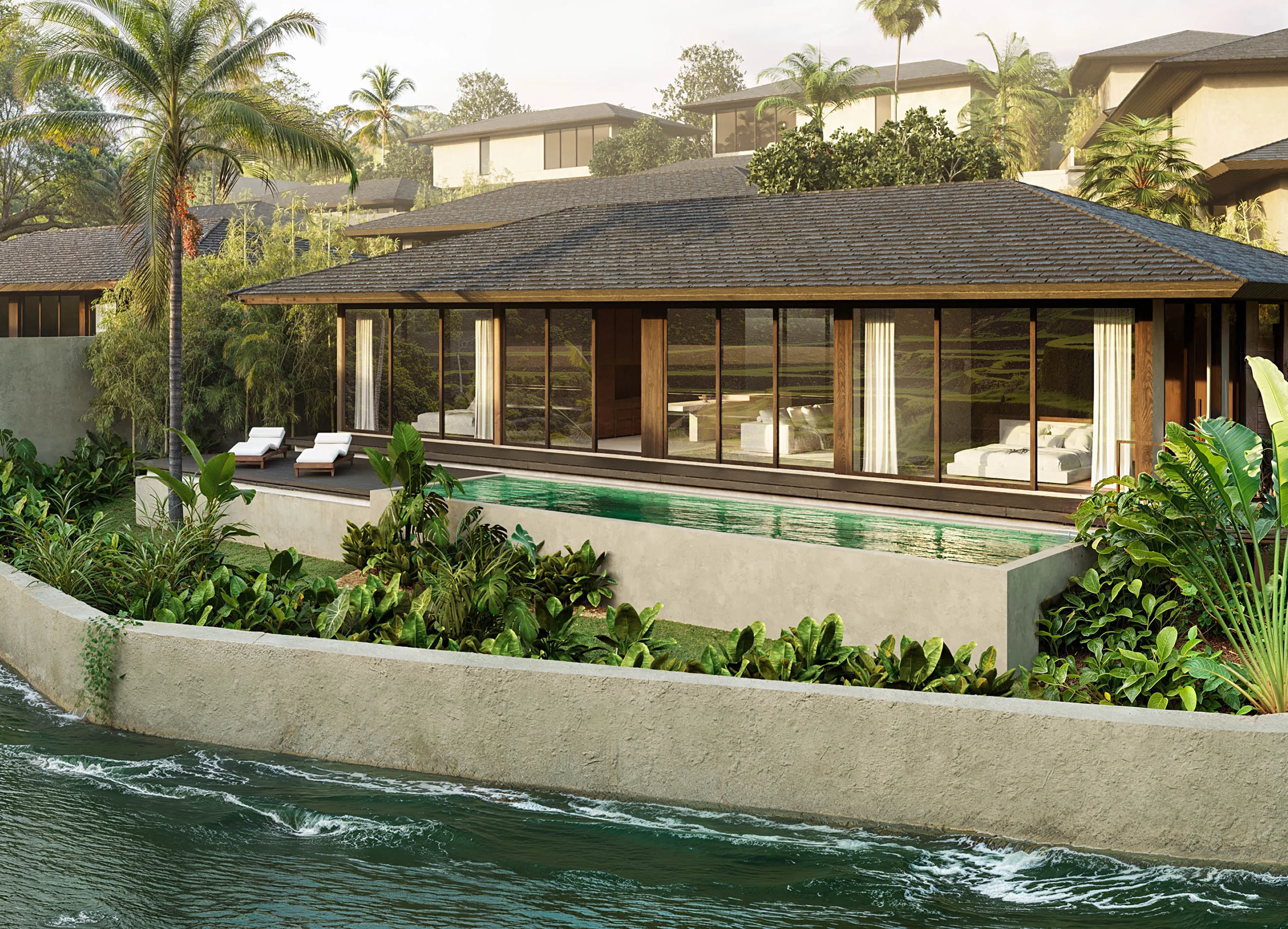 Single-story villa with a dark shingled roof and timber beams, glass walls opening onto a long pool beside a waterway – Villa Yonira 2BR, a 2-bedroom villa in Buwit, Bali