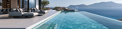 Modern villa terrace with lounge seating beside an infinity pool overlooking the sea and mountains – Spain