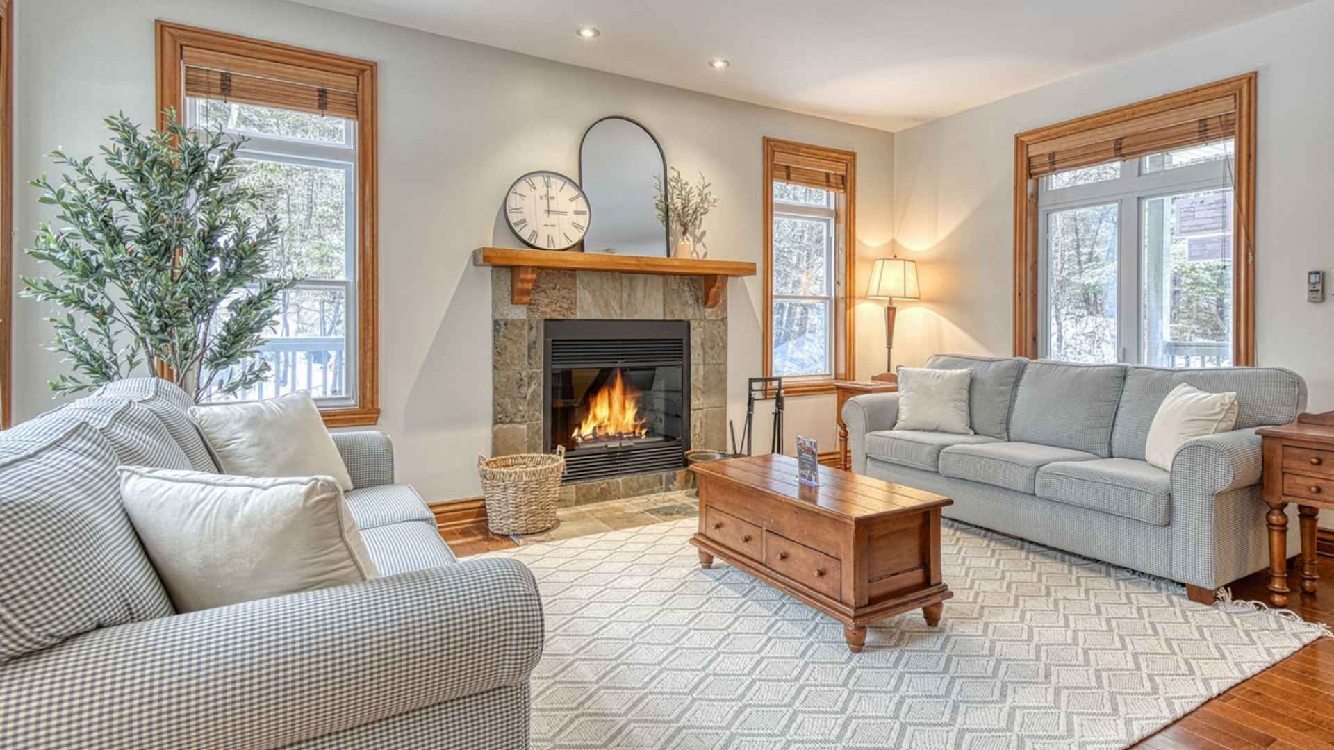 Vue intérieure d'un chalet de luxe avec jacuzzi près des pistes de ski, présentant un salon confortable avec cheminée, dans une propriété de HM Vacation Rentals