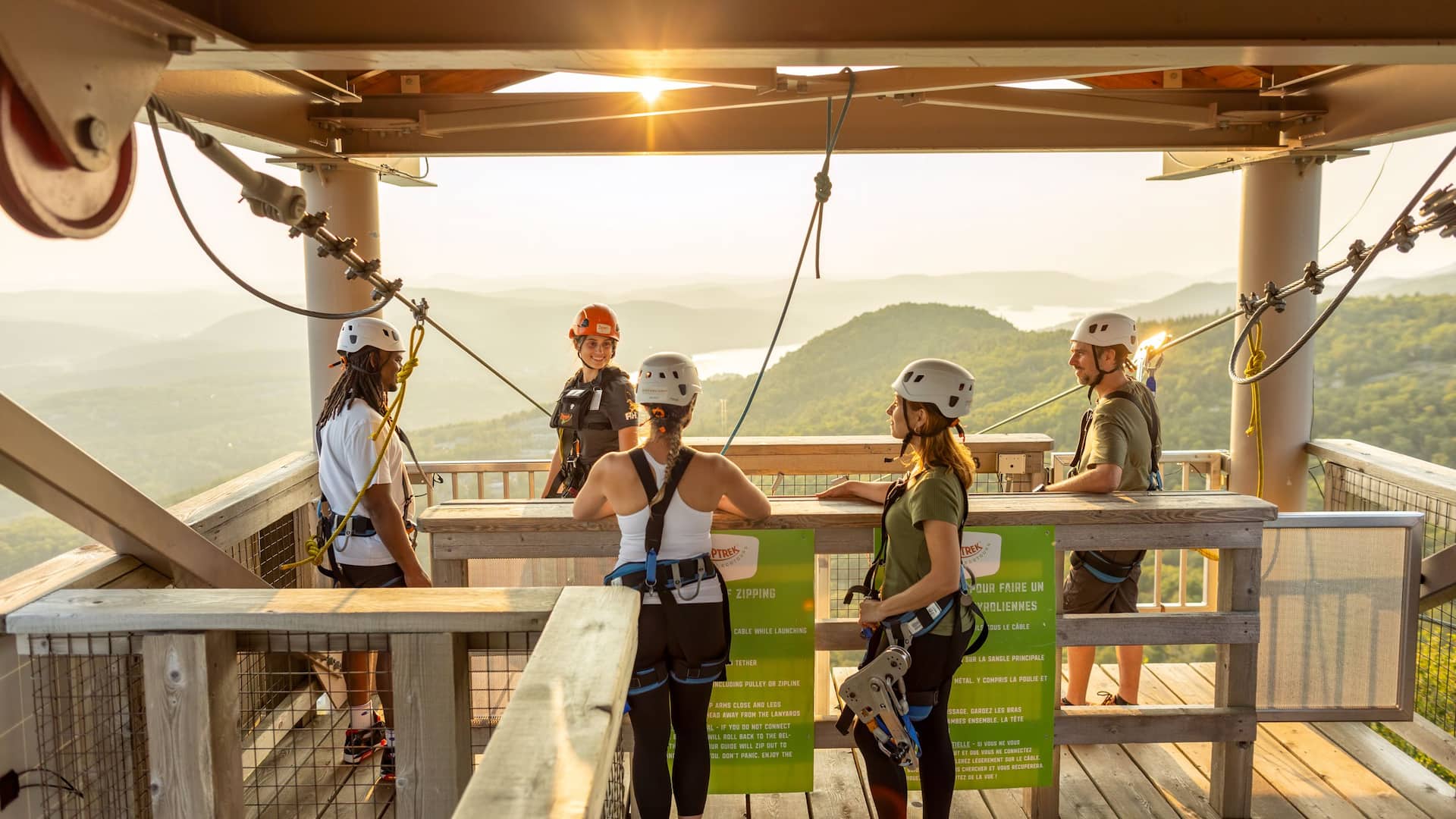 Des gens sur une plateforme de tyrolienne surplombant le paysage du Mont Tremblant.