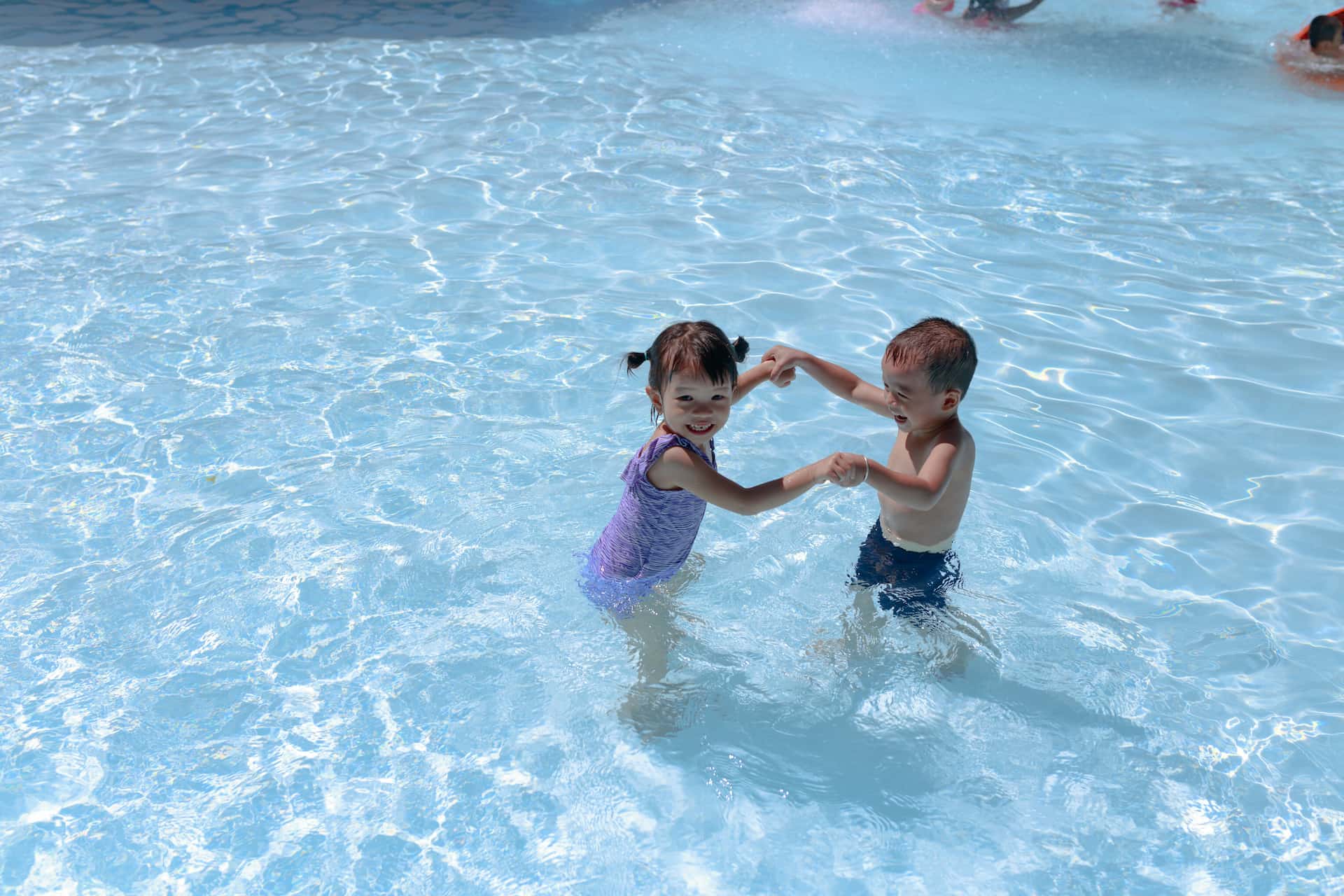 Deux jeunes enfants jouant dans une piscine.