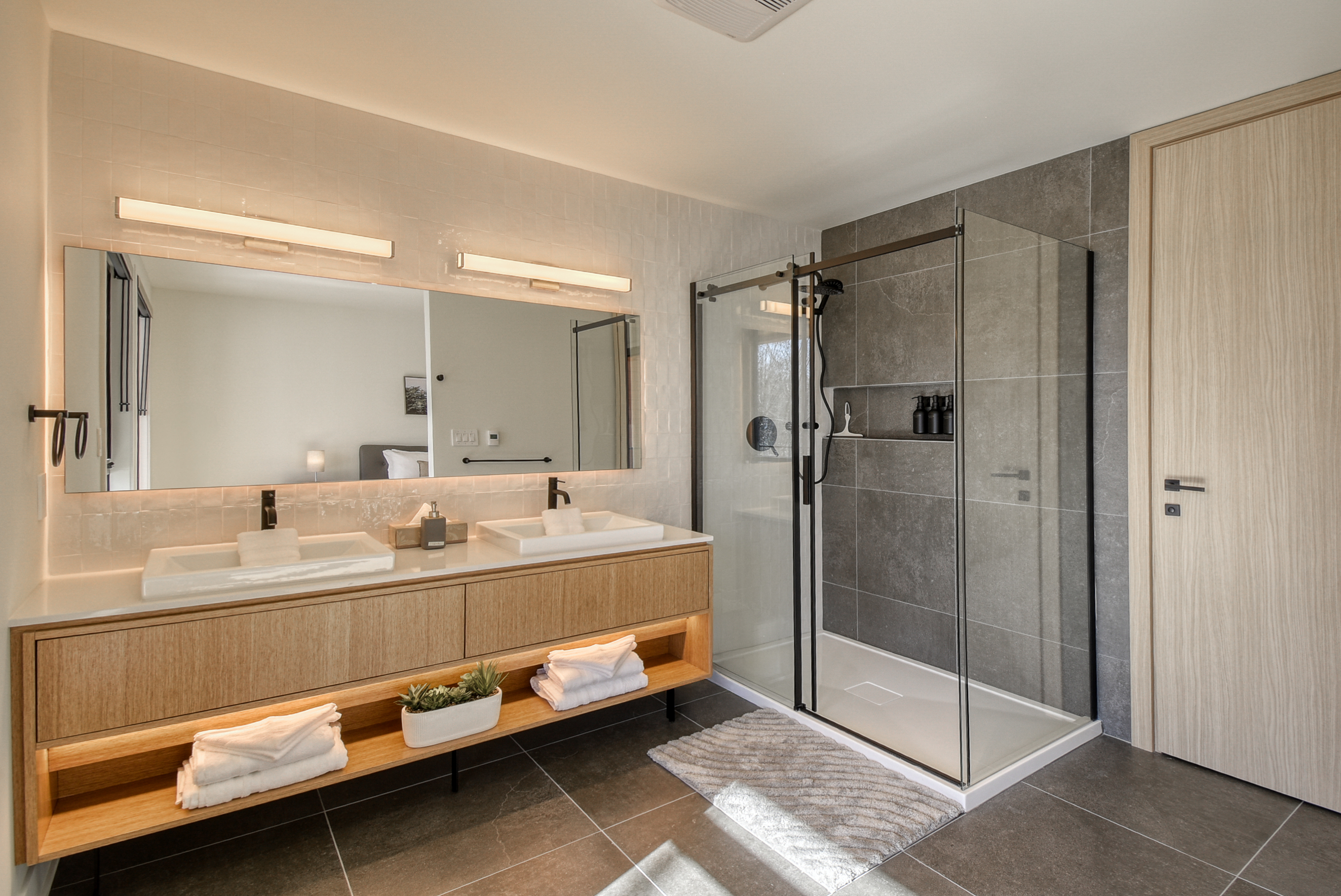 alle de bain moderne avec douche vitrée et meuble double vasque.