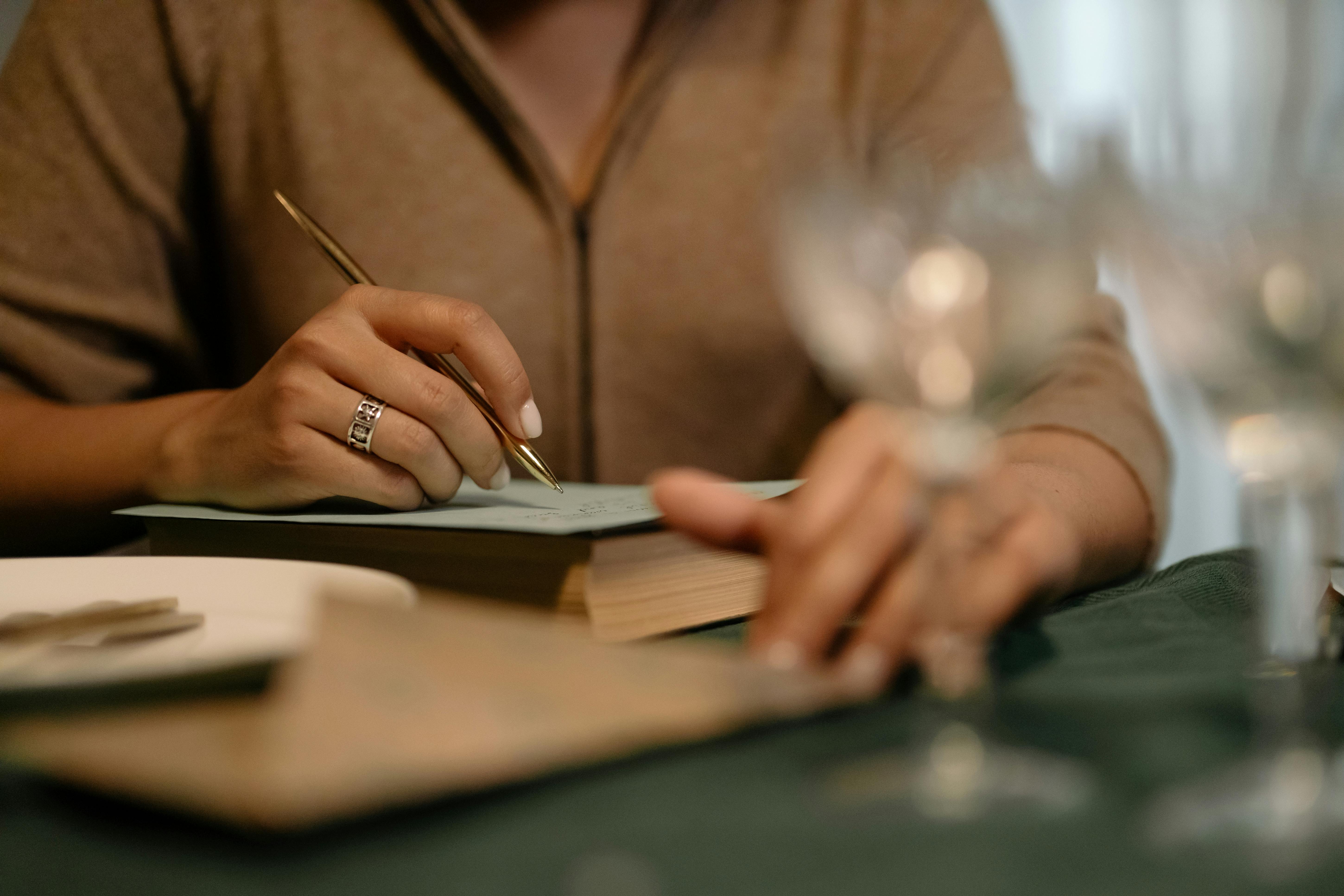 Gros plan d'une personne écrivant une checklist dans une ambiance chaleureuse.