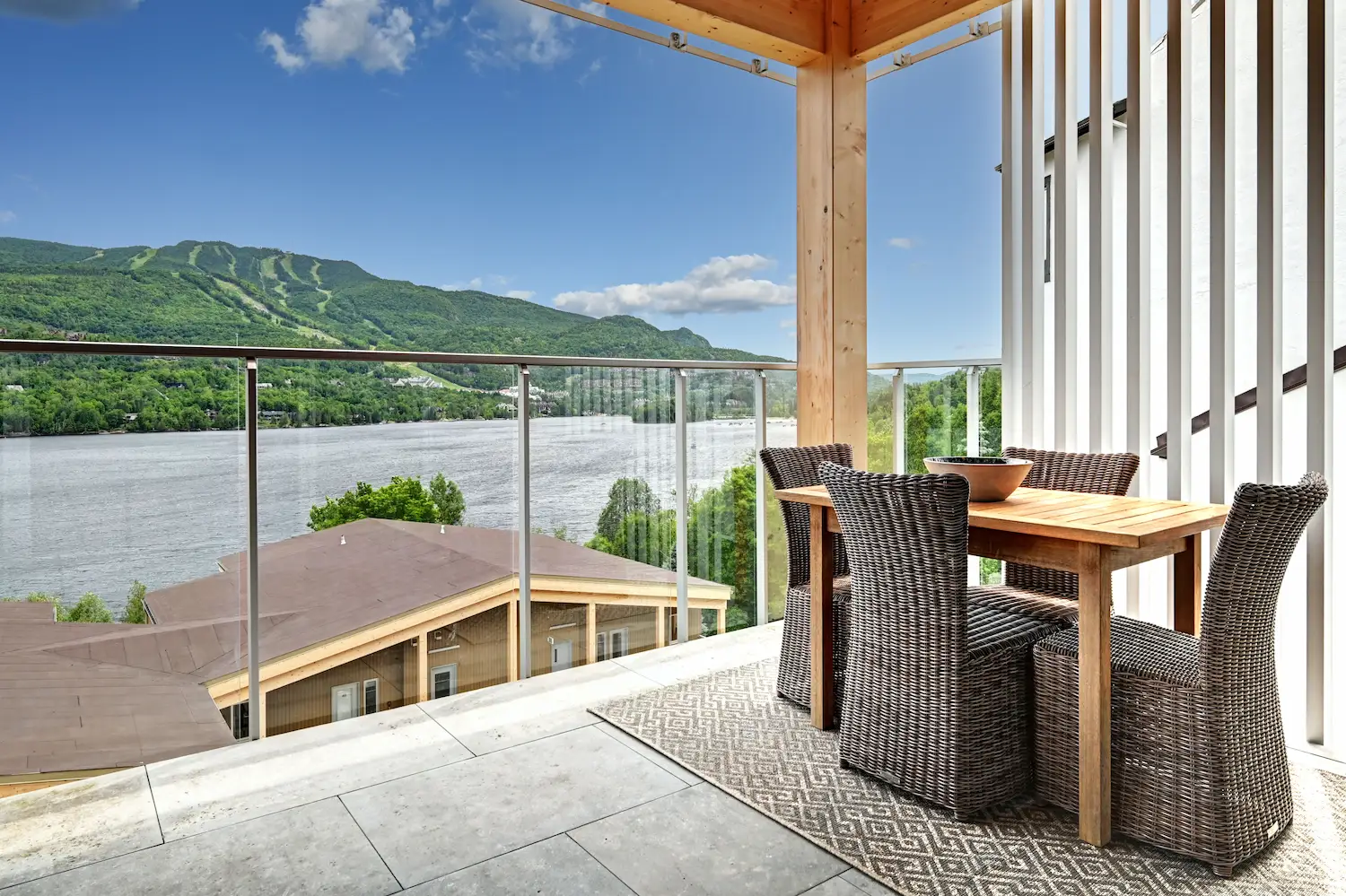 Mont-Tremblant vacation rental patio with grill, seating, and lake view.